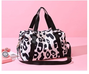 Detail of waterproof leopard print travel bag featuring sturdy nylon handles and metal D-ring