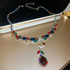 Vue détaillée du collier argenté avec cristaux colorés et pendentif goutte rouge