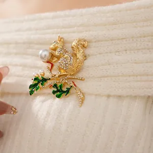 Broche écureuil vintage avec strass scintillants et perle sur un pull en maille blanc