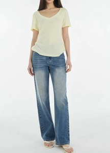 Full view of loose tencel wool V-neck t-shirt paired with light blue wide-leg jeans