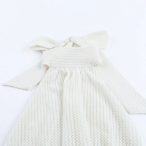 Detail of knit hollow-out texture and large bow on ivory white halter vacation dress