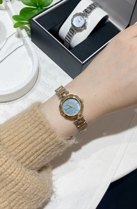 Detailed macro view of petal-shaped case and two-tone steel band women's quartz watch