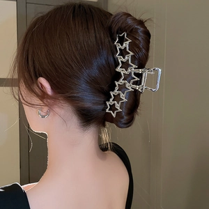 Détail d'une pince à cheveux étoile en métal argenté avec strass sur un mannequin