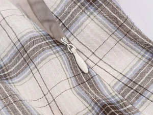 Dettaglio del tessuto a quadri in cotone e lino blu e beige con cerniera a scomparsa