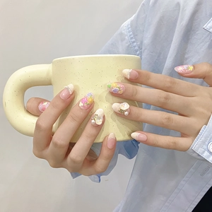 Handmade press-on nails with 3D floral petals, pearls, and bows on long oval shape
