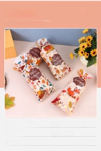 Detail view of Thanksgiving gift bags with maple leaves and squirrel prints for autumn candy
