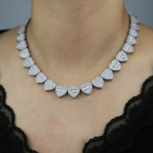 Close-up of heart-shaped silver necklace with pavé zircon stones on neck model