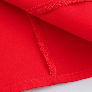 Detail of red balloon hem dress showing premium stitching and fabric texture