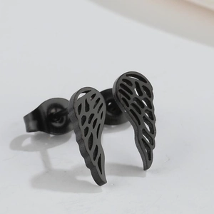 Macro detail of black feather wing stud earrings featuring retro hollowed out patterns