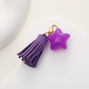 Detail view of purple star charm and matching tassel with gold lobster clasp