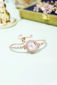 Detailed macro shot of rose gold women's watch with rhinestone bezel and quartz dial