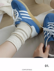 Dettaglio ravvicinato di scarpe in pelle scamosciata blu con calze in maglia spessa