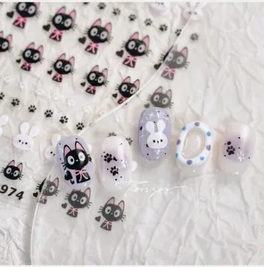 Detailed view of cute black cat and white rabbit nail art stickers with pink bow patterns