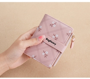Detail of pink PU leather wallet with diamond quilting and small white floral patterns