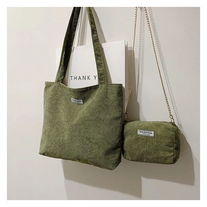 Detail of grass green corduroy tote bag set with golden metal chain strap accessory