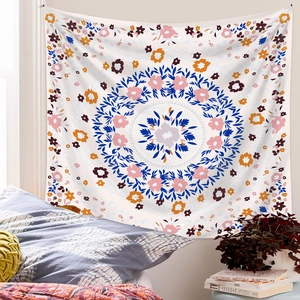Detailed view of floral mandala tapestry hanging in a cozy bedroom setup