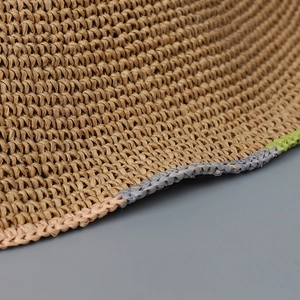 Close-up of handmade woven straw hat featuring detailed colorful contrast stitching on brim