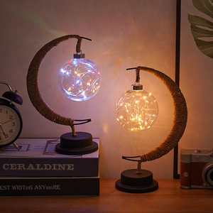 Detail of moon-shaped LED night lamps with hemp rope winding and colorful warm light