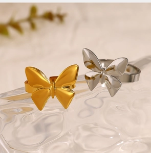 Detailed view of two polished gold and silver bow-shaped rings on a marble background