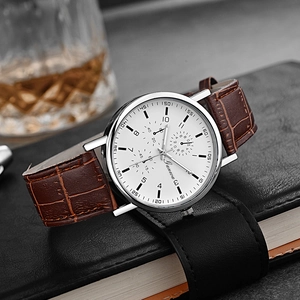 Macro detail of Geneva quartz watch with brown leather strap on a professional business desk