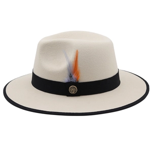 Detail of a beige wool felt fedora featuring a black ribbon, feather, and anchor badge