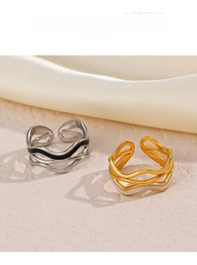 Detail of wavy drip oil rings in silver with black and gold with white enamel
