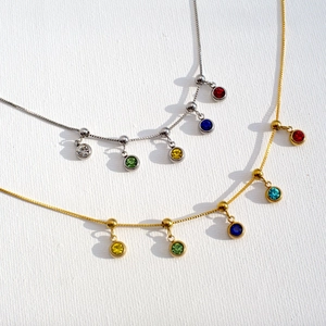 Detailed view of gold and silver stainless steel necklaces with colorful birthstone charms