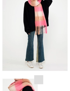 Detail view of pink and brown plaid scarf featuring soft cashmere-like texture and fringe