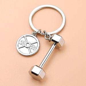 Mini porte-clés haltère en argent pour amateurs de fitness sur fond de couleur douce