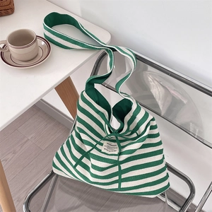 Detailed close-up of a large striped canvas tote bag with shoulder strap on a modern chair