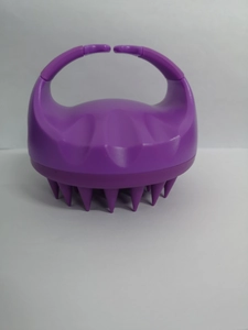 Close-up of a purple silicone scalp massager brush with an ergonomic handle for wet and dry hair
