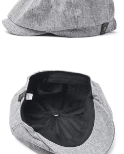 Detail of grey linen newsboy cap showing side profile and inner lining with adjustable strap