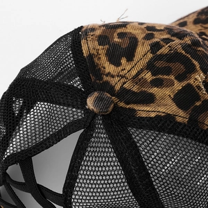 Detailed close-up of leopard print fabric and stitching on a distressed mesh baseball cap