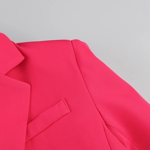 Detail shot of hot pink blazer featuring notched lapels and precise stitching craft