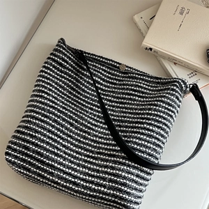 Détail du sac cabas en tweed rayé avec fermeture magnétique argentée et bandoulière en cuir