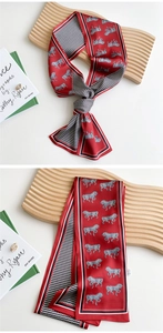 Detail of red twilly silk scarf with horse print and chevron pattern edges