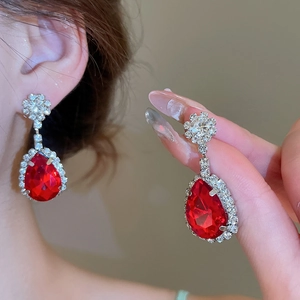 Primo piano di orecchini vintage con pietre a goccia rosse e dettagli in diamanti