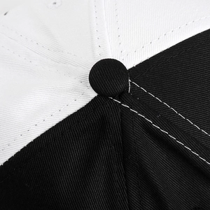 Detailed close-up of a baseball cap crown featuring black and white contrast stitching