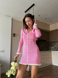Mini abito in maglia rosa con finiture bianche e bottoni indossato da una modella