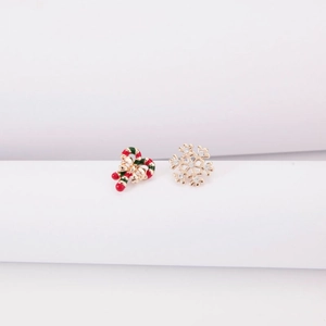 Detail of asymmetric Christmas earrings with candy cane and golden snowflake designs