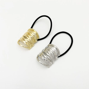 Close-up of gold and silver hair ties with irregular metal textures on a white background