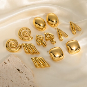 Set of six pairs of gold vintage geometric earrings displayed on beige silk fabric