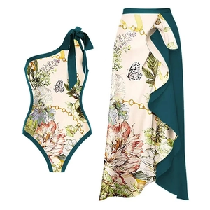 Detail of floral one-shoulder swimsuit set featuring a matching wrap skirt with ruffles