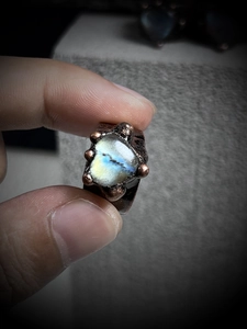 Macro shot of natural labradorite heart ring with vintage bronze ball-prong setting
