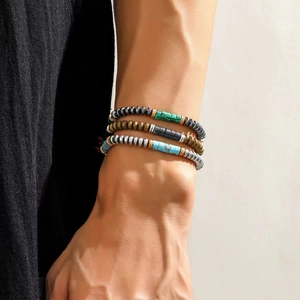 Set of three handmade men's beaded bracelets in turquoise and hematite on wrist