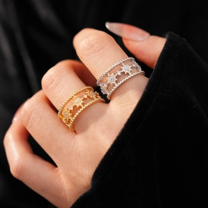 Detail of gold and silver open rings with hollow star patterns and sparkling zircons