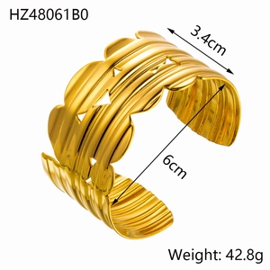 Detailed view of gold stainless steel bangle with wavy edges and triangular cutouts