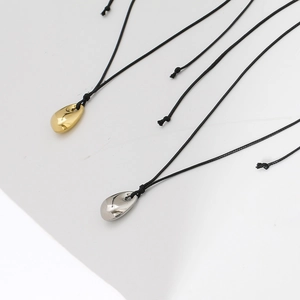 Minimalist gold and silver teardrop pendants on black wax ropes for men and women