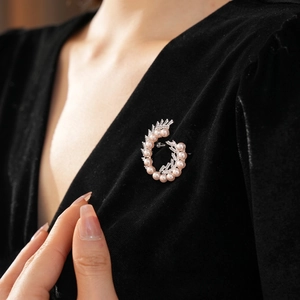 Spiral pearl brooch with zircon stones on black velvet dress for elegant look