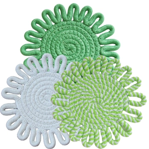 Close-up of three woven cotton rope placemats in green, white and striped patterns